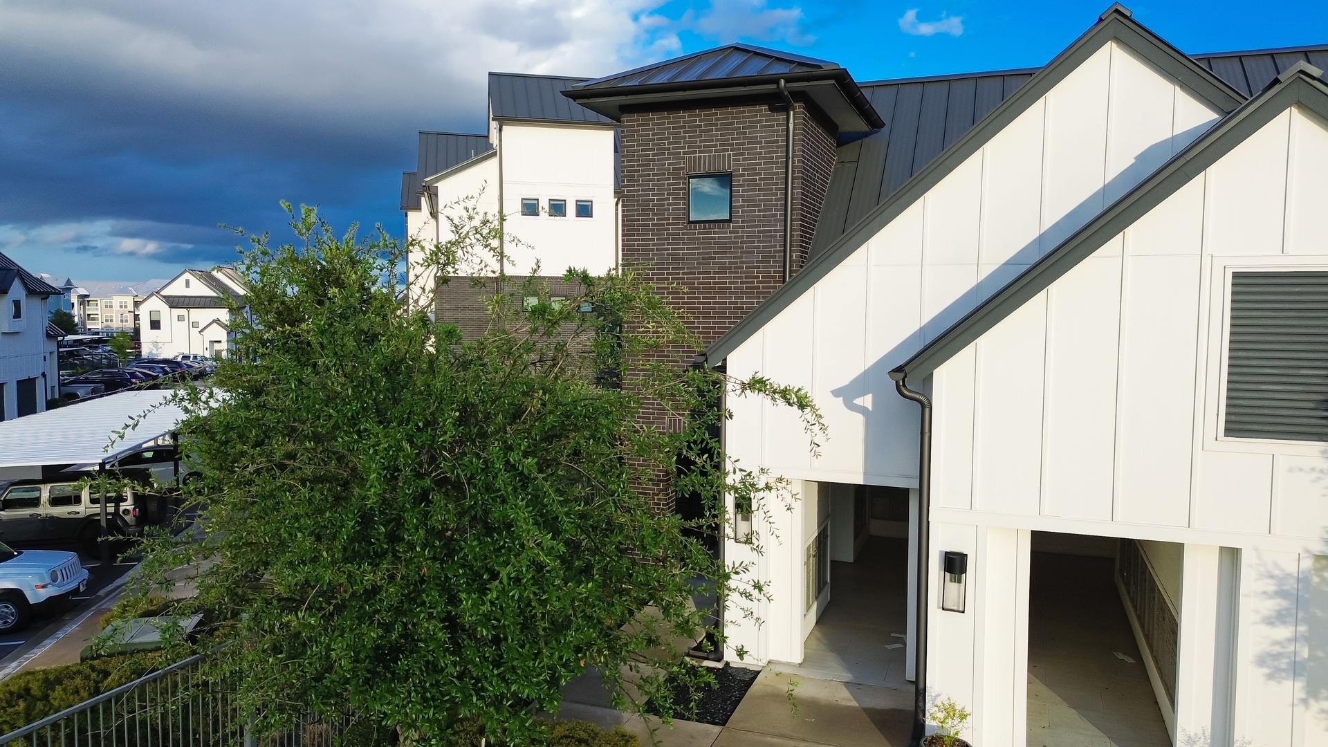Close-up metal roofing of new apartment complex in fast growing area near Pflugerville northeast of downtown Austin, Texas, modern multistory building rental community, housing market, aerial
